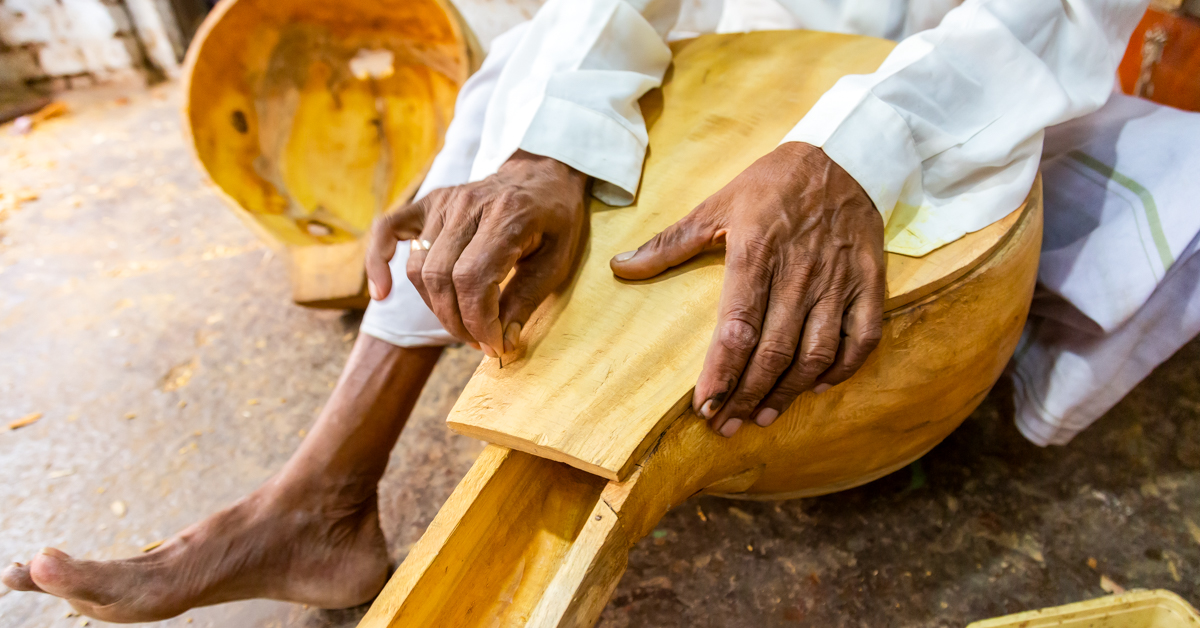 An old Man making handmade design on wooden Saraswati Veena 